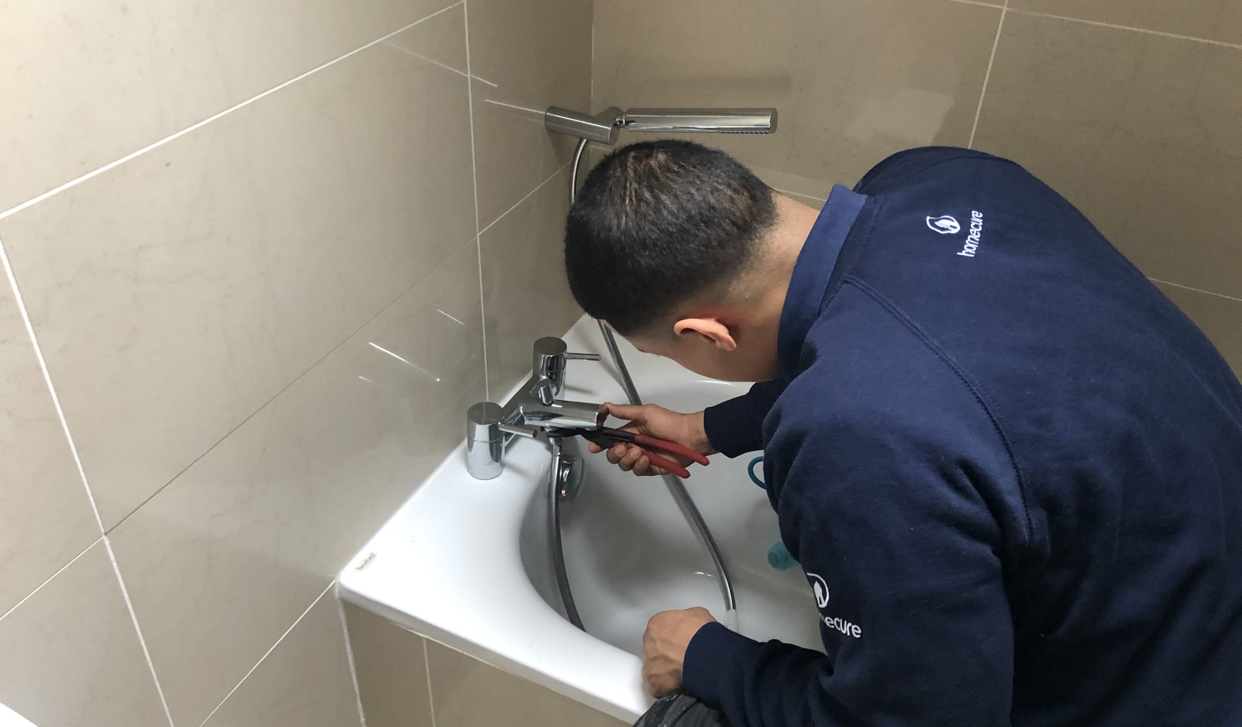 Our quick response, professional plumber in [city] fixing a leaky tap.